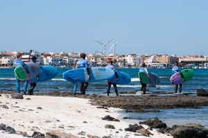 Surfklasse auf dem steinigen Weg ins Wasser Surfklasse auf dem steinigen Weg ins Wasser