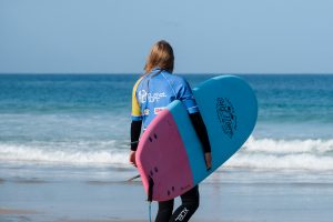 Surfschülerin im Surfcamp Fuerteventura auf dem Weg ins Wasser Surfschülerin im Surfcamp Fuerteventura auf dem Weg ins Wasser