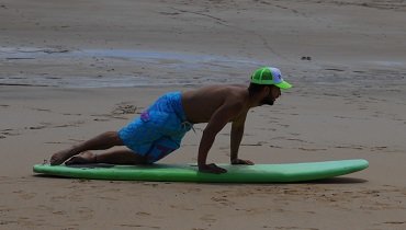 Du streckst deine Arme und ziehts dabei gleichzeitig dein Surfboard unter dir in die richtige Position. Du streckst deine Arme und ziehts dabei gleichzeitig dein Surfboard unter dir in die richtige Position.