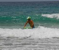 Positioniere dein Surfbrett auf dem Wasser mit Tail senkrecht zur Welle und der Surfboardspitze in Richtung Strand.
