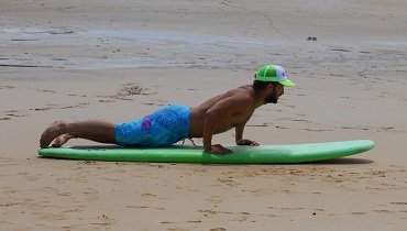 Du ziehst dich in die richtige Position auf dein Surfboard. Du ziehst dich in die richtige Position auf dein Surfboard.