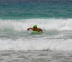 Hast du die richtige Lage auf deinem Surfboard erreicht, wirf noch einmal einen kontrollierenden Schulterblick auf die ankommende Welle hinter dir.