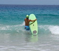 Passiert dich eine brusthohe Welle, kannst du diese mit Surfboard an der Seite sicher überqueren.