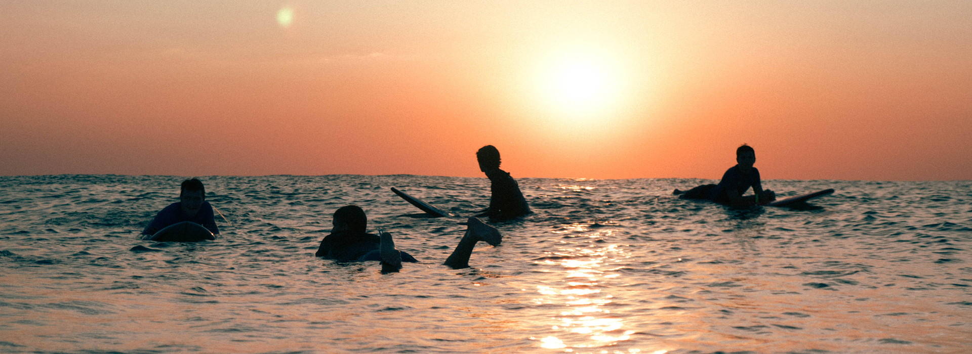 Sonnenuntergang bei jugendlichen Surfern